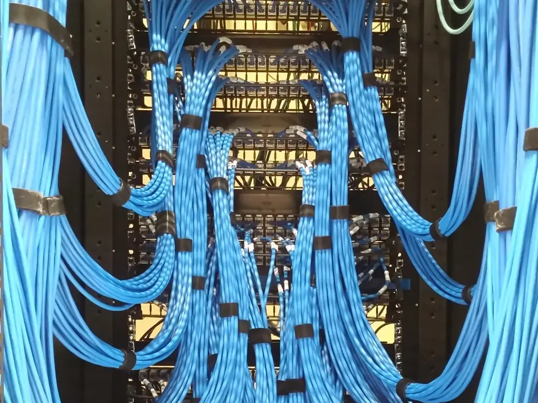 Neatly dressed blue network cables in an office network rack